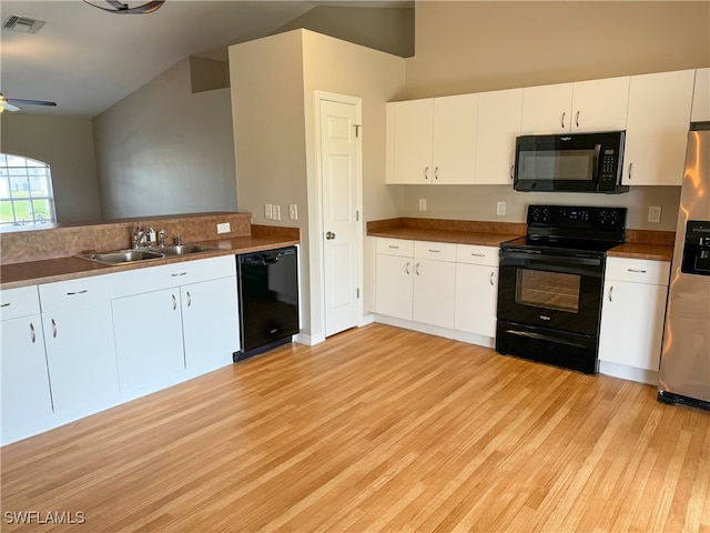 kitchen featuring black appliances, white cabinets, lofted ceiling, and light hardwood / wood-style flooring