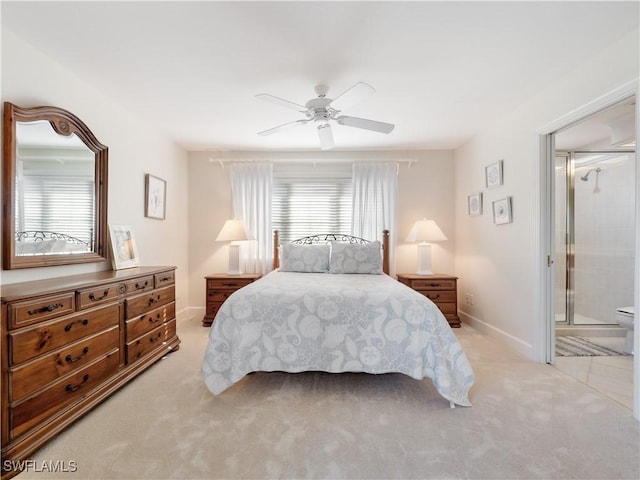 carpeted bedroom featuring ceiling fan and ensuite bath