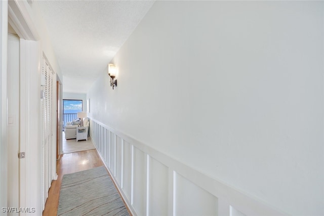 hallway featuring a textured ceiling and light wood-type flooring