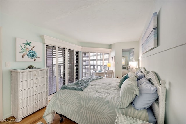 bedroom featuring access to exterior and hardwood / wood-style flooring