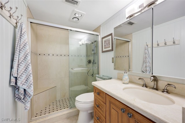 bathroom featuring tile patterned flooring, vanity, toilet, and a shower with door