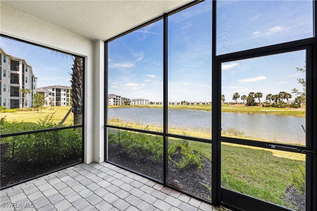 unfurnished sunroom featuring a water view