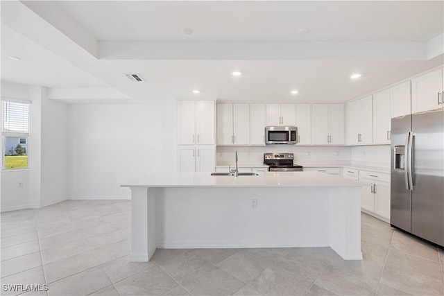 kitchen featuring white cabinetry, sink, stainless steel appliances, an island with sink, and light tile patterned floors