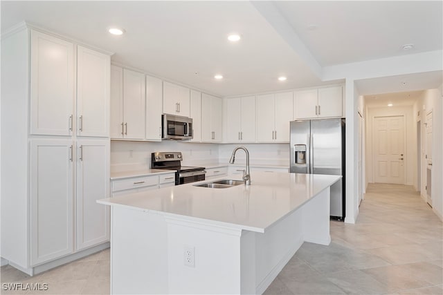 kitchen featuring white cabinets, a kitchen island with sink, sink, and appliances with stainless steel finishes