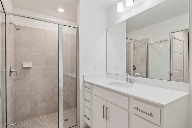 bathroom featuring vanity and a shower with door