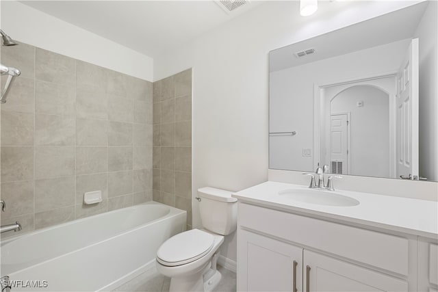 full bathroom with tiled shower / bath, tile patterned flooring, vanity, and toilet