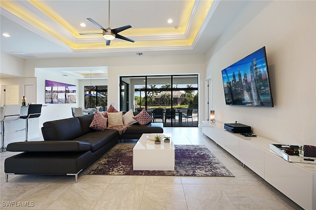 living room featuring ceiling fan, a raised ceiling, and crown molding