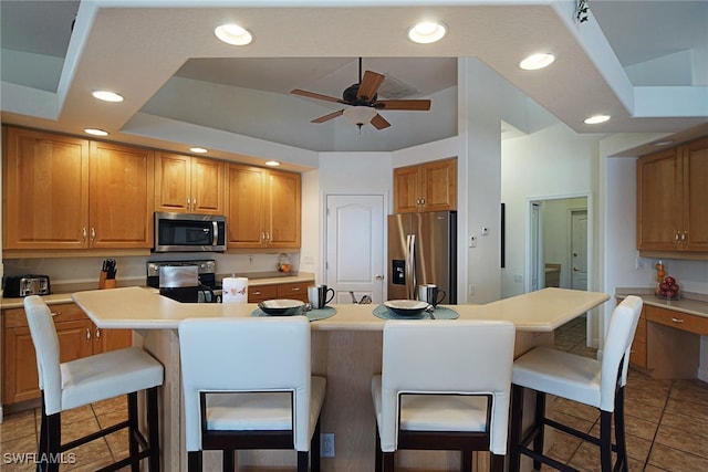 kitchen featuring a kitchen breakfast bar, appliances with stainless steel finishes, lofted ceiling, and a center island