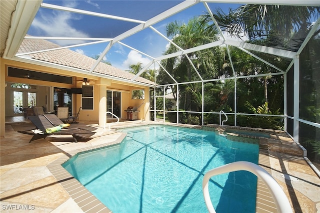 view of pool featuring ceiling fan, a patio area, and glass enclosure