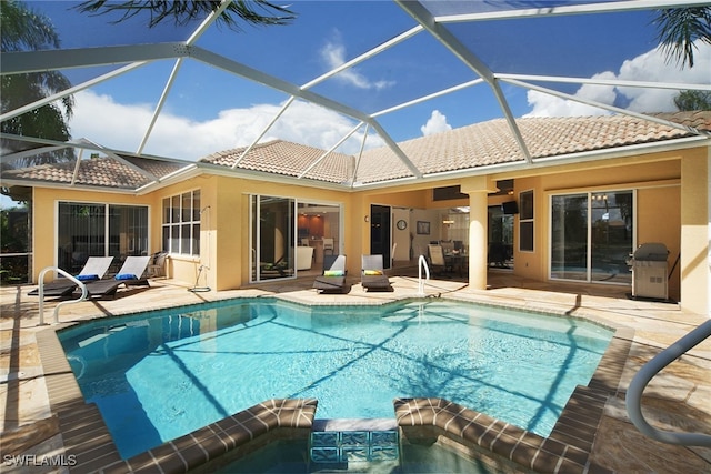 view of swimming pool with a patio area, a lanai, an in ground hot tub, and grilling area