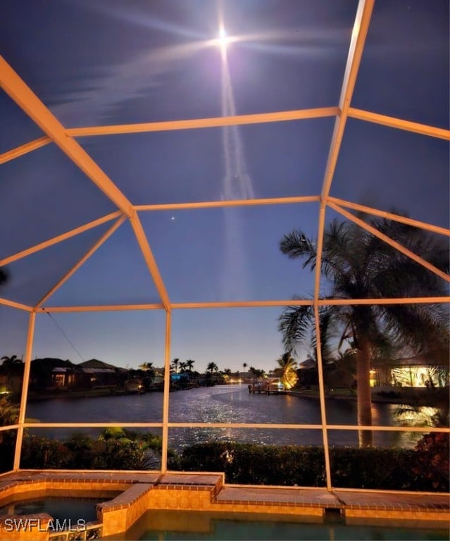 pool at dusk with glass enclosure and a water view