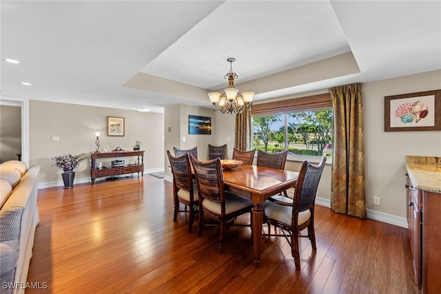 dining space featuring dark hardwood / wood-style floors and an inviting chandelier