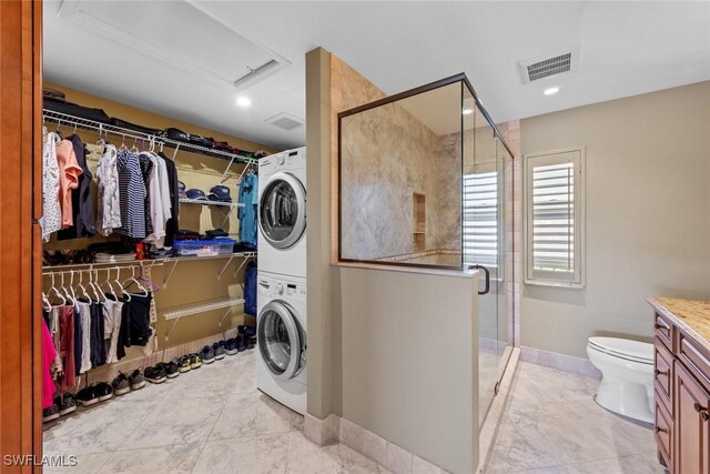 laundry area with stacked washer and clothes dryer