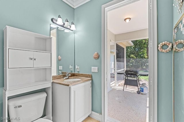 bathroom featuring toilet, vanity, a wealth of natural light, and ornamental molding