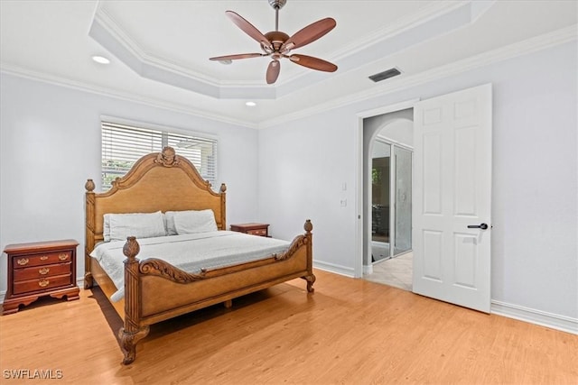 bedroom featuring ceiling fan, ornamental molding, and a raised ceiling