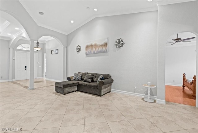 living room featuring ceiling fan, light tile patterned floors, crown molding, and decorative columns