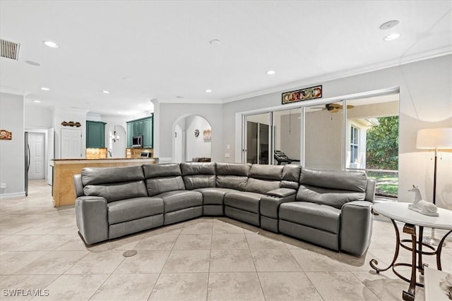 living room featuring ceiling fan, light tile patterned floors, and crown molding