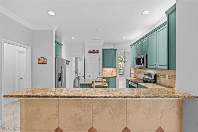 kitchen featuring kitchen peninsula, decorative backsplash, crown molding, green cabinetry, and stainless steel appliances