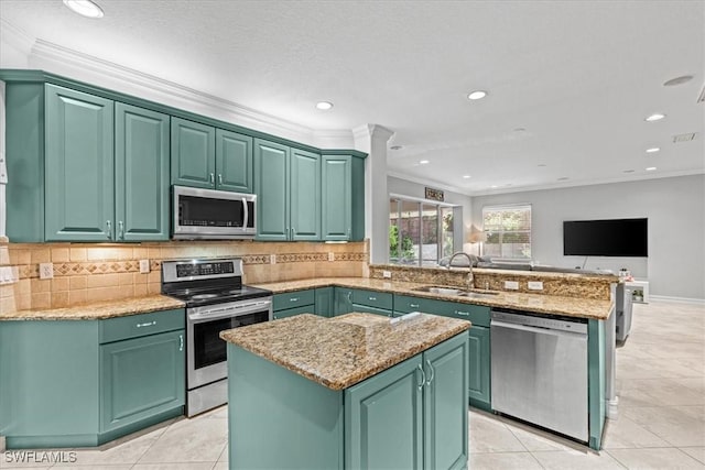 kitchen with green cabinets, appliances with stainless steel finishes, a center island, and sink