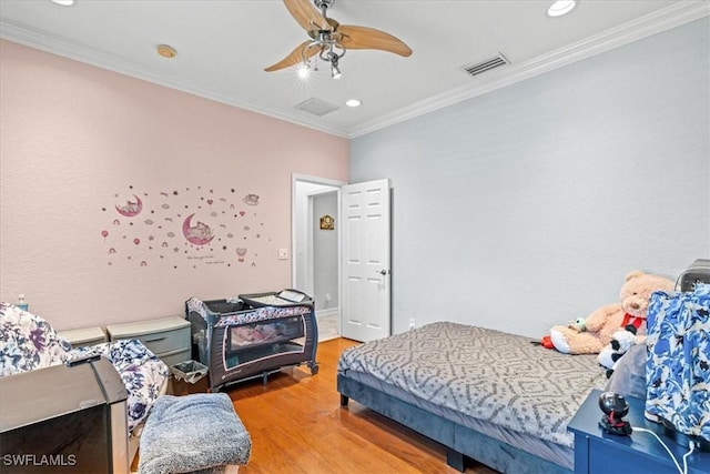 bedroom featuring ceiling fan, hardwood / wood-style flooring, and ornamental molding