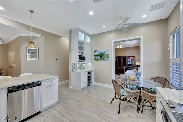 kitchen with light stone countertops, white cabinetry, beverage cooler, decorative light fixtures, and appliances with stainless steel finishes