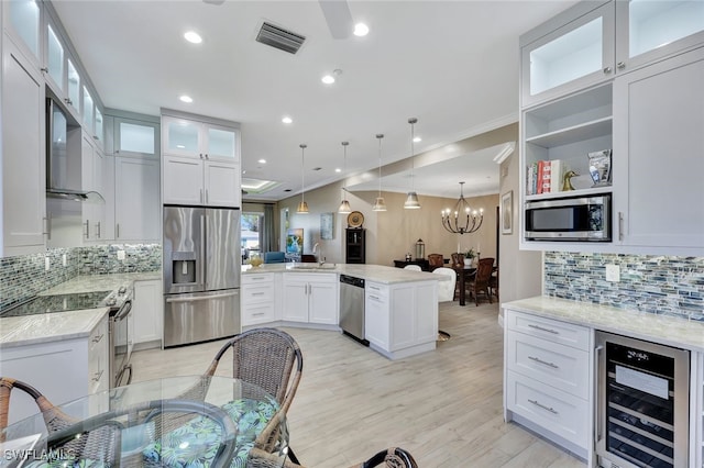 kitchen with white cabinetry, wine cooler, light stone counters, decorative backsplash, and appliances with stainless steel finishes