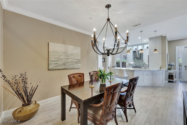 dining room featuring plenty of natural light, crown molding, and light hardwood / wood-style flooring