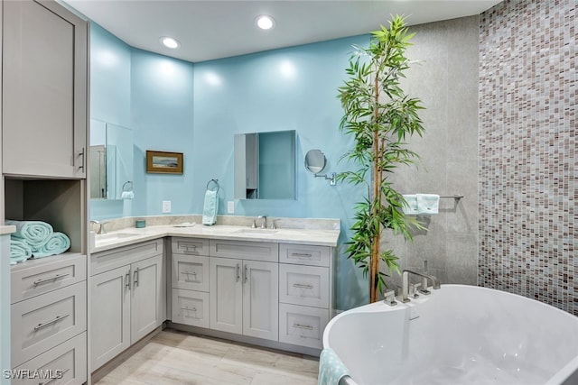 bathroom featuring vanity, hardwood / wood-style flooring, and a bathtub