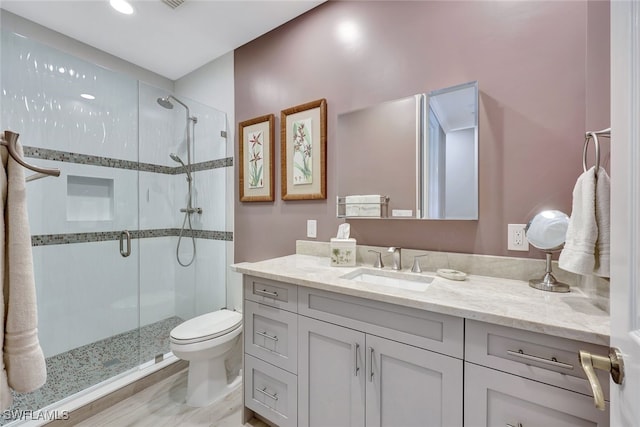 bathroom with vanity, hardwood / wood-style flooring, toilet, and walk in shower