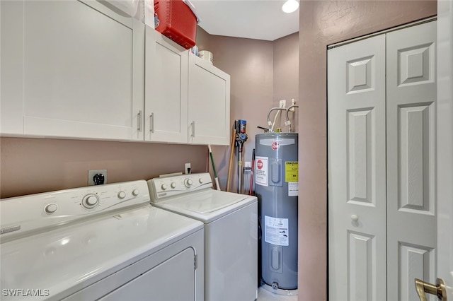 clothes washing area featuring cabinets, washing machine and dryer, and water heater