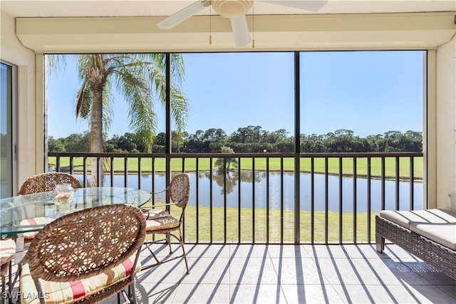 sunroom / solarium with a wealth of natural light, a water view, and ceiling fan