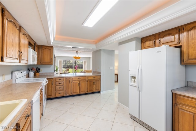 kitchen with sink, light tile patterned floors, a tray ceiling, pendant lighting, and white appliances