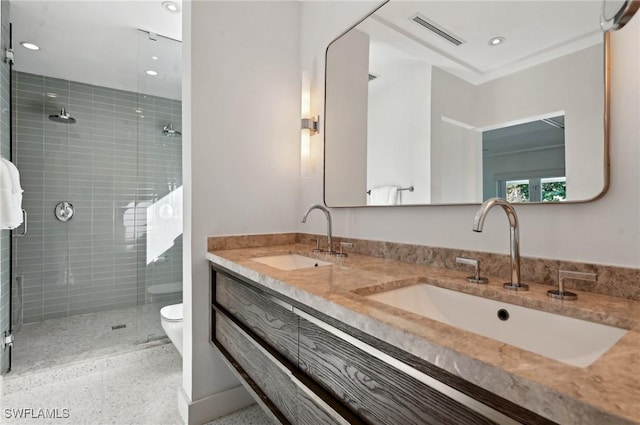 bathroom featuring double vanity, a stall shower, visible vents, and a sink