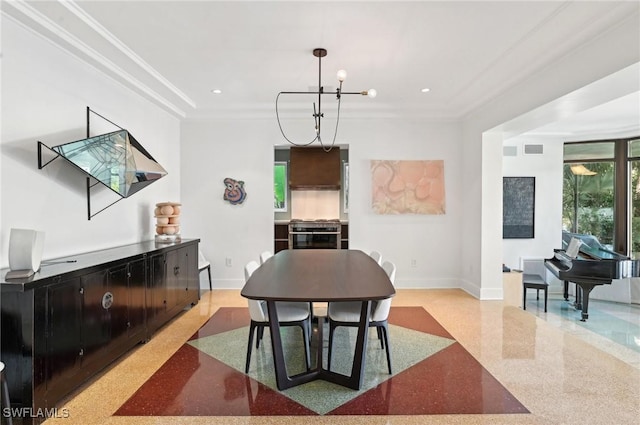 dining space with baseboards, a chandelier, light speckled floor, and crown molding