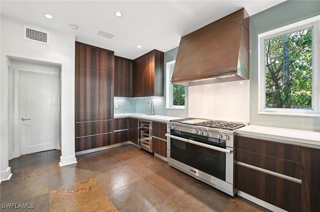 kitchen with visible vents, wine cooler, modern cabinets, premium range hood, and double oven range