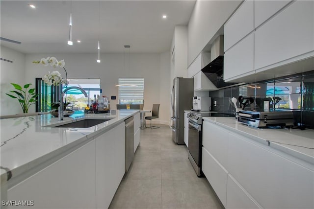 kitchen with backsplash, sink, appliances with stainless steel finishes, decorative light fixtures, and white cabinetry