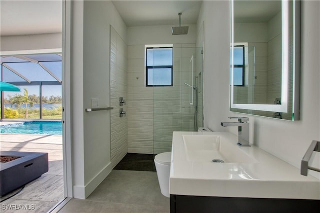 bathroom featuring a tile shower, vanity, and toilet