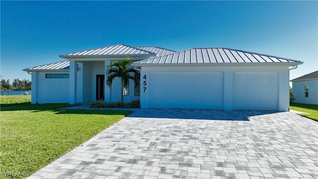 view of front of house featuring a garage and a front lawn