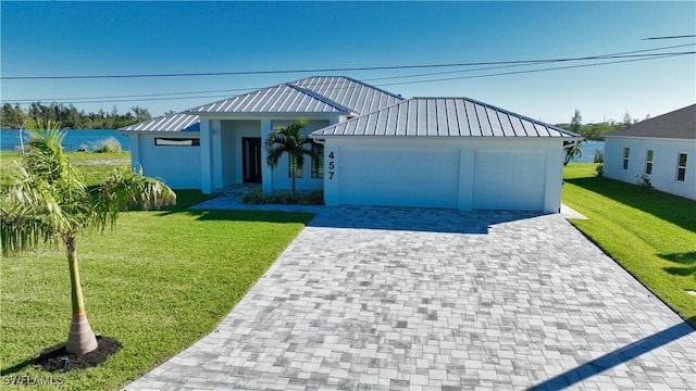 view of front of home with a water view, a front lawn, and a garage