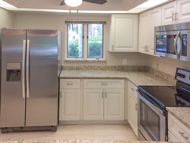 kitchen with white cabinets, ceiling fan, light stone countertops, and stainless steel appliances