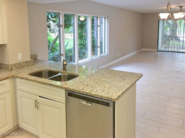 kitchen with an inviting chandelier, sink, stainless steel dishwasher, light stone countertops, and white cabinetry