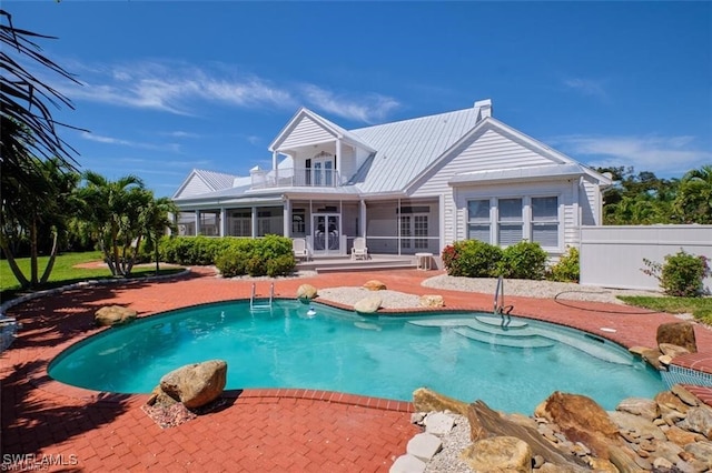 view of swimming pool featuring a sunroom and a patio