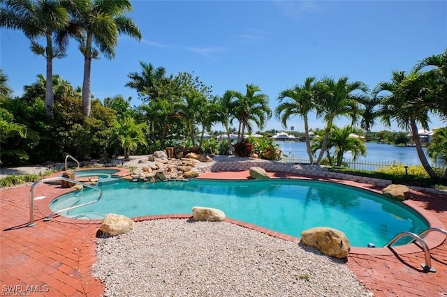 view of pool with a water view and an in ground hot tub