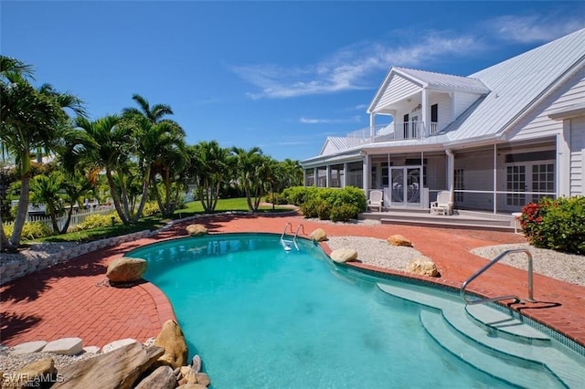 view of swimming pool featuring a patio area and a sunroom