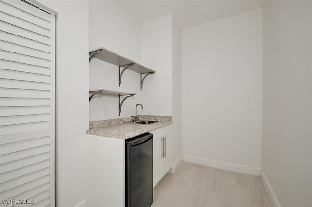 bar featuring white cabinetry, sink, and black dishwasher