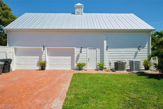 garage with a yard and central air condition unit