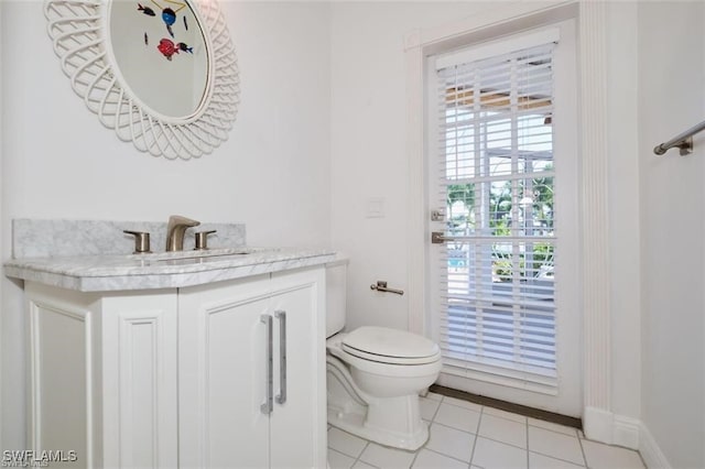 bathroom with toilet, vanity, and tile patterned floors