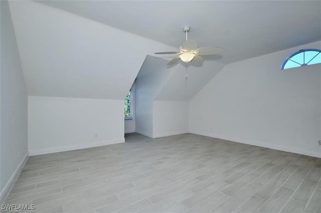 additional living space with ceiling fan, a wealth of natural light, and vaulted ceiling