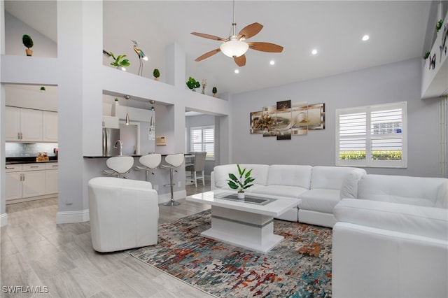 living room with high vaulted ceiling, plenty of natural light, and ceiling fan