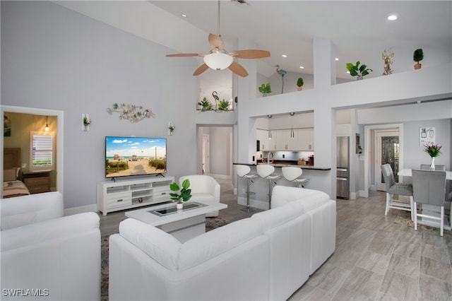 living room with ceiling fan, sink, and high vaulted ceiling